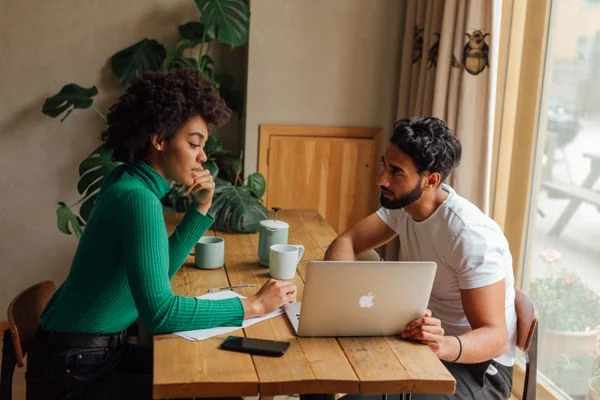 Building Portfolio That Gets - Freelancer discussing project work with a client over a laptop