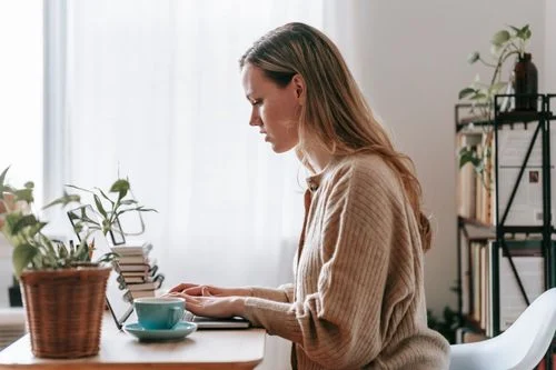 Upwork Fiverr Contra Which - Freelancer concentrating on her laptop at home
