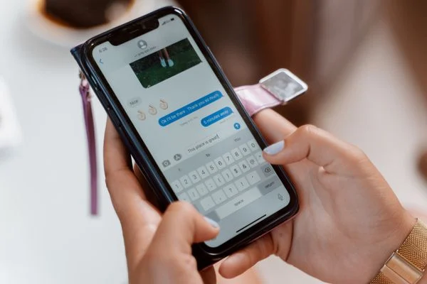 What Is AI Memory / AI Memory - Hands typing on a smartphone with chat messages visible
