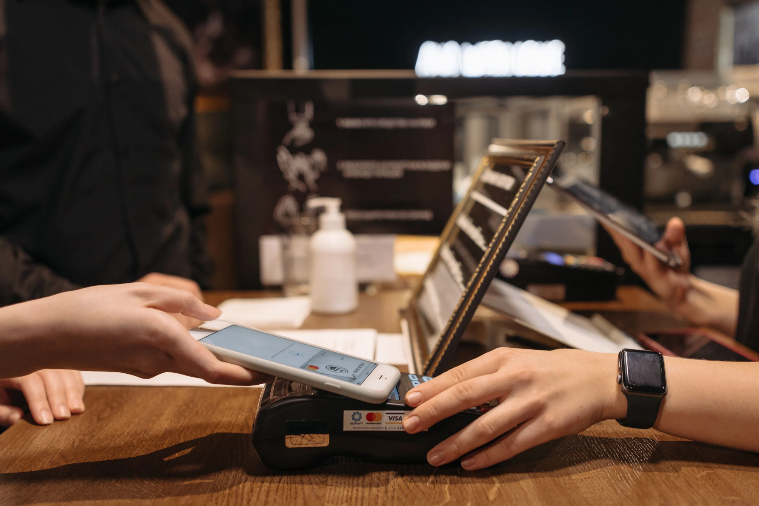 Digital Wallet - Person paying at a store by tapping a smartphone on a payment terminal