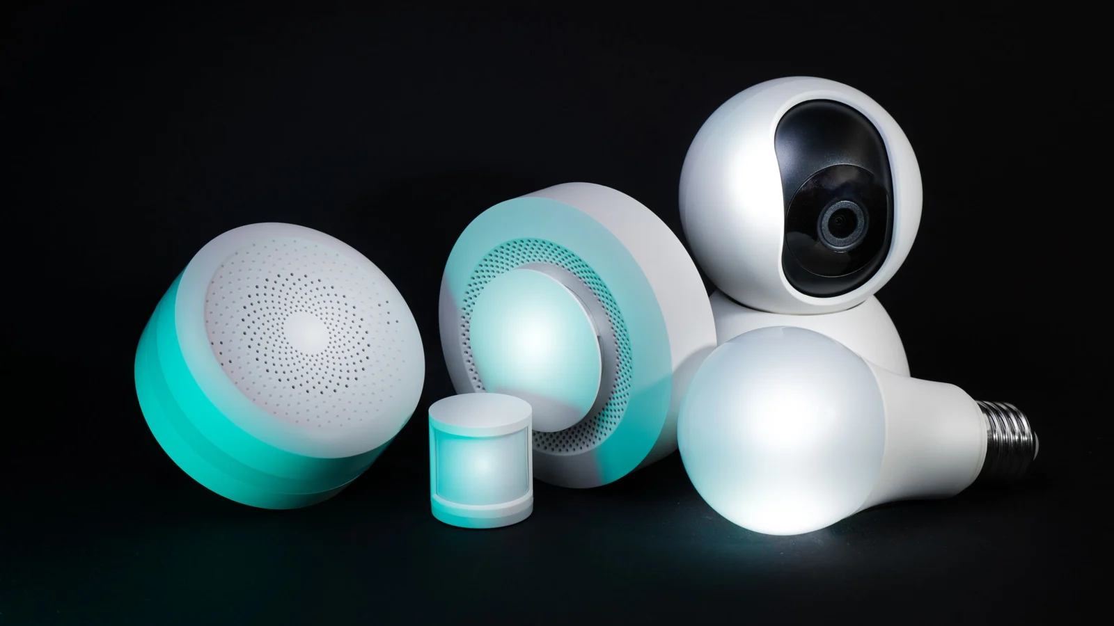 Photo by Jakub Zerdzicki on Pexels (free to use). Collection of smart home devices including a camera, bulbs, and sensors on a dark background.