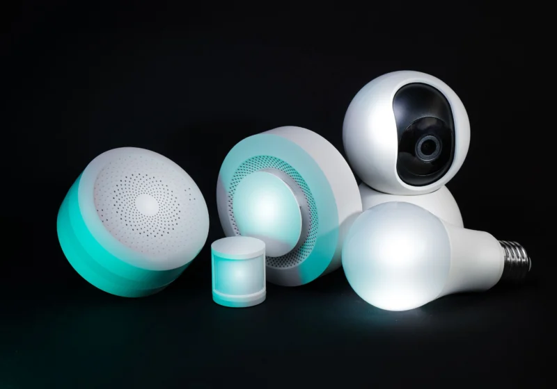 Photo by Jakub Zerdzicki on Pexels (free to use). Collection of smart home devices including a camera, bulbs, and sensors on a dark background.