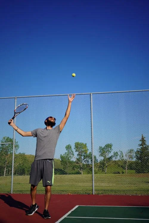 Tiebreak Tennis Format - Tennis player serving on an outdoor court on a sunny day